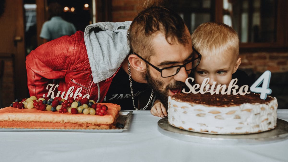 Father and child enjoying a birthday celebration with delicious cakes and festive decorations.